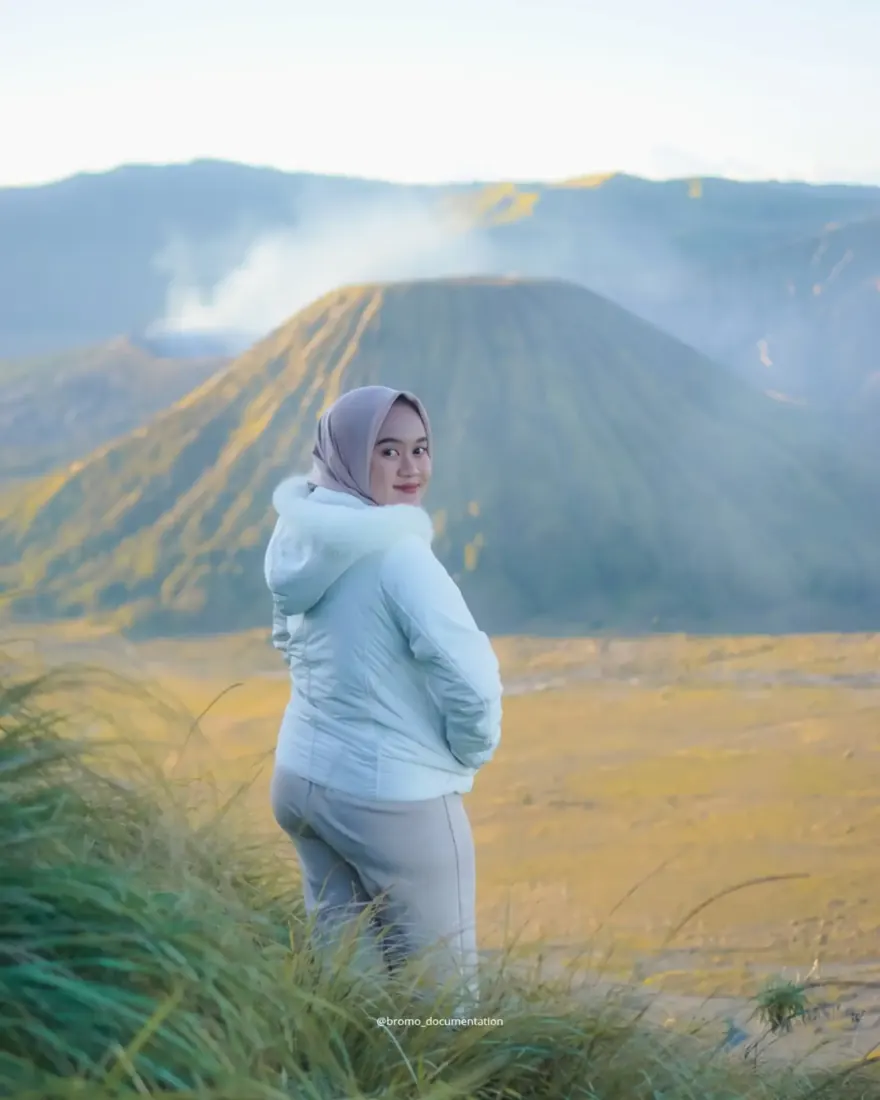 Tamu berfoto dengan latar Gunung Bromo berasap
