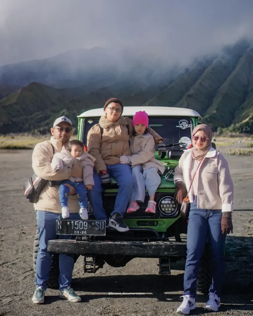 Keluarga tamu berfoto di jeep hijau